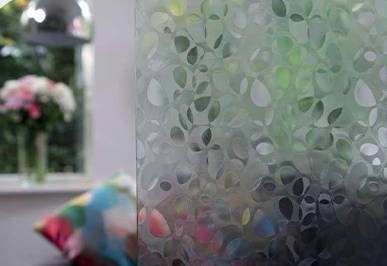 Close-up of patterned obscure glass beside a clear window pane in a UPVC window, Chandlers Ford